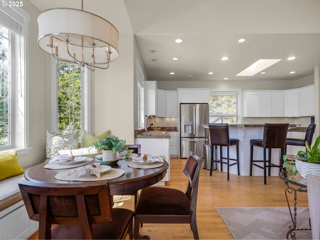 571 Antler Rd, Cannon Beach, OR 97110 - dining space featuring a skylight, recessed lighting, light wood-style floors, and a chandelier