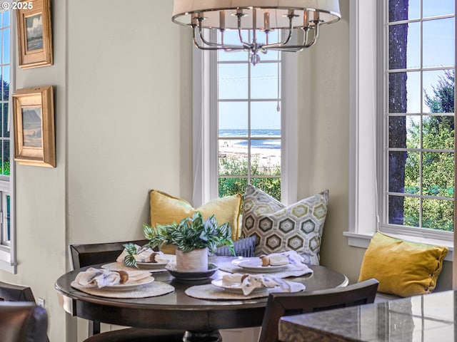 dining space featuring a water view and a chandelier