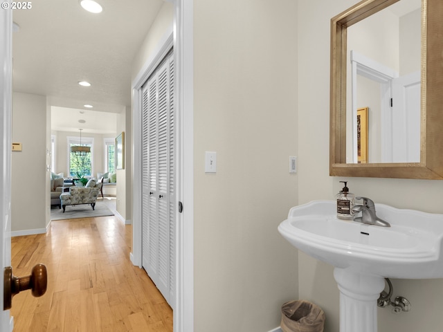 bathroom with baseboards, recessed lighting, and wood finished floors