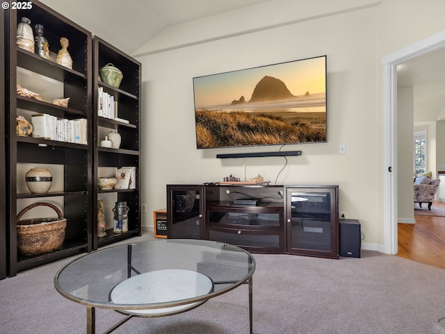 living area featuring carpet floors, baseboards, and lofted ceiling