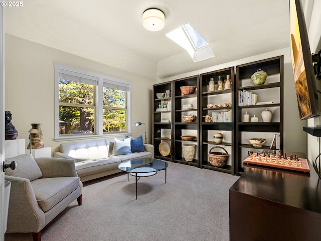 sitting room featuring vaulted ceiling with skylight and carpet floors