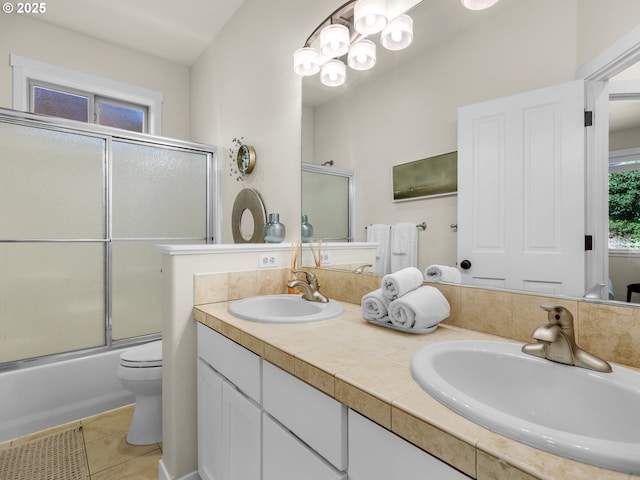 full bathroom featuring double vanity, toilet, a sink, and tile patterned flooring
