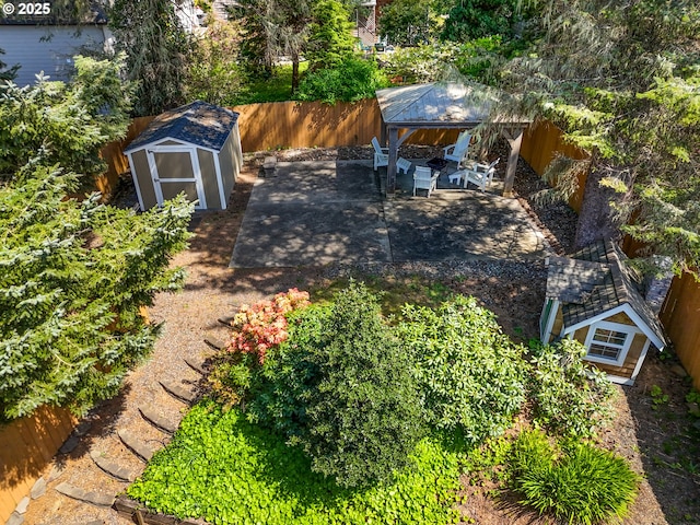 view of yard with a storage shed, an outbuilding, a gazebo, a fenced backyard, and a patio