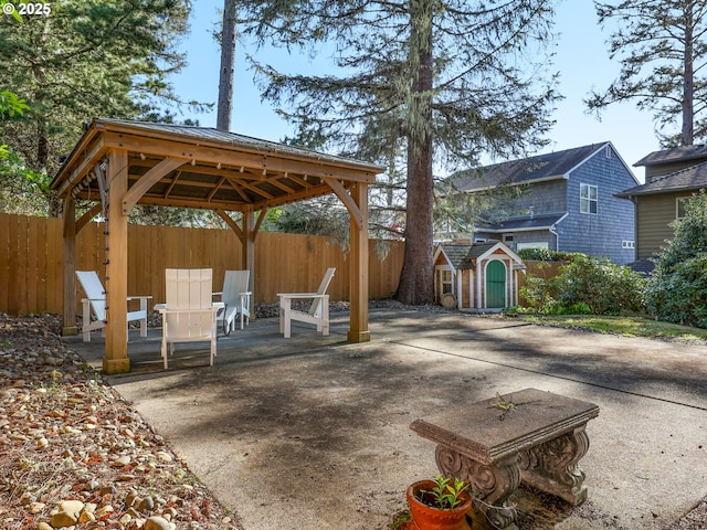 view of patio / terrace with a storage shed, an outbuilding, a gazebo, and a fenced backyard