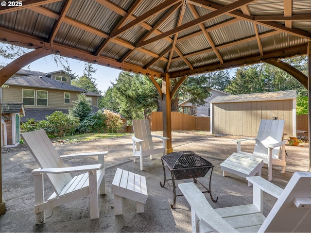 view of patio / terrace featuring fence, an outbuilding, a gazebo, and an outdoor fire pit