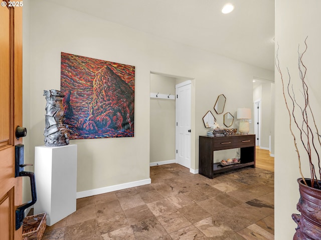 foyer entrance with baseboards and stone finish flooring
