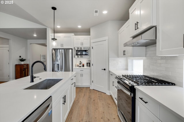 1332 SE 14th Ave, Canby, OR 97013 - kitchen featuring appliances with stainless steel finishes, a sink, under cabinet range hood, light wood-style flooring, and white cabinets
