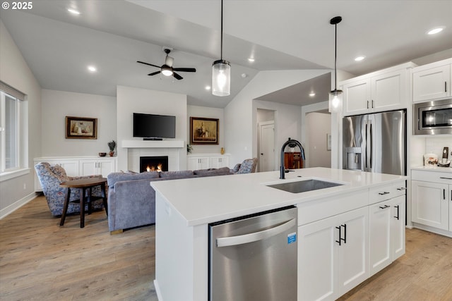 1332 SE 14th Ave, Canby, OR 97013 - kitchen featuring appliances with stainless steel finishes, a sink, light wood-style floors, lofted ceiling, and white cabinetry