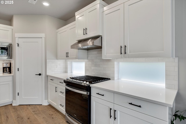 1332 SE 14th Ave, Canby, OR 97013 - kitchen with appliances with stainless steel finishes, under cabinet range hood, light wood-style floors, light countertops, and white cabinets