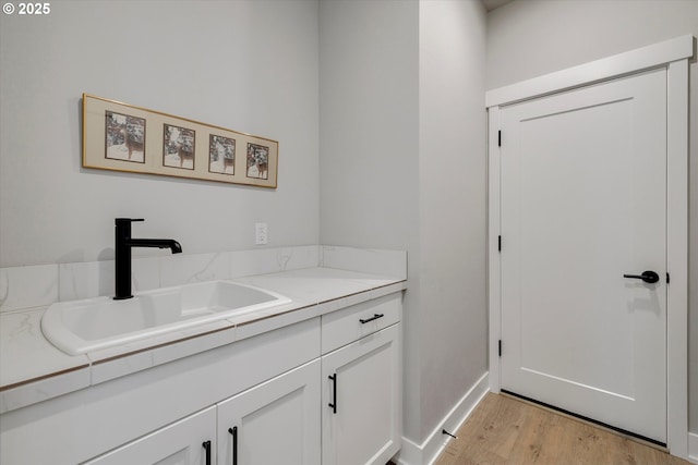 1332 SE 14th Ave, Canby, OR 97013 - laundry area featuring a sink, light wood finished floors, and baseboards