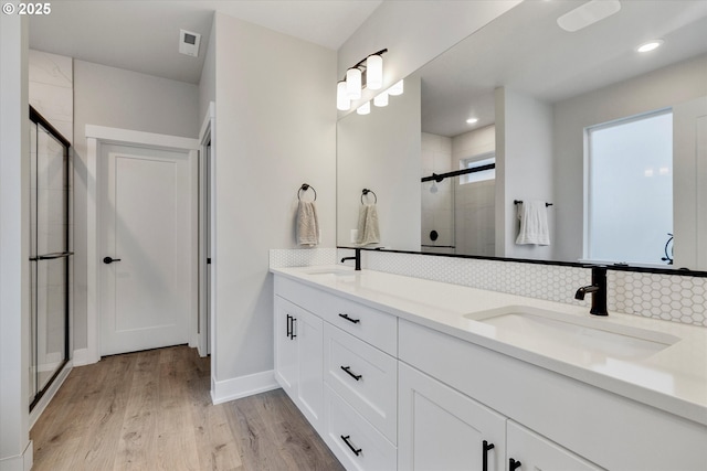 1332 SE 14th Ave, Canby, OR 97013 - bathroom featuring a stall shower, tasteful backsplash, wood finished floors, double vanity, and baseboards