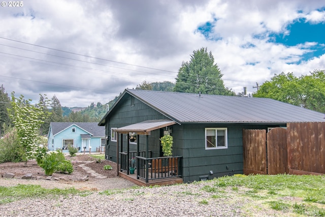 view of front of house with metal roof, fence, and crawl space