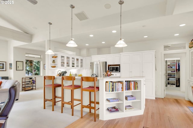 kitchen with visible vents, white cabinetry, stainless steel appliances, and open shelves