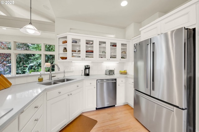 kitchen featuring backsplash, appliances with stainless steel finishes, white cabinets, and a sink