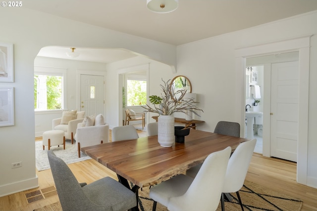 2814 NE 34th Ave, Portland, OR 97212 - dining room with plenty of natural light, light wood-style flooring, arched walkways, and baseboards