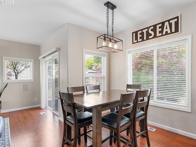 dining area with plenty of natural light, baseboards, and wood finished floors