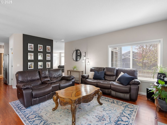 living area with plenty of natural light, baseboards, and wood finished floors