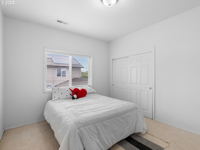 bedroom featuring a closet, baseboards, carpet flooring, and visible vents
