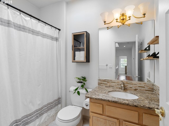 bathroom with an inviting chandelier, decorative backsplash, toilet, and vanity