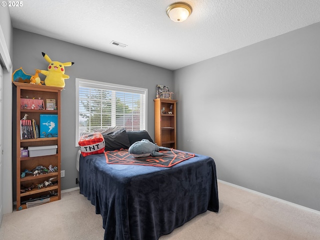 carpeted bedroom featuring visible vents, a textured ceiling, and baseboards