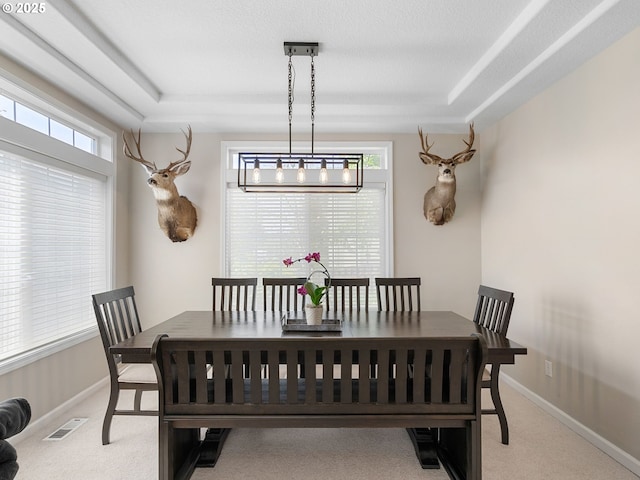 dining room featuring baseboards, visible vents, and light carpet