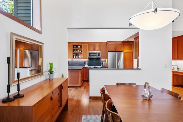 dining space featuring a towering ceiling and wood finished floors