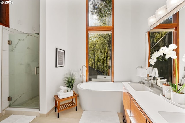 bathroom with double vanity, a marble finish shower, a wealth of natural light, and a soaking tub