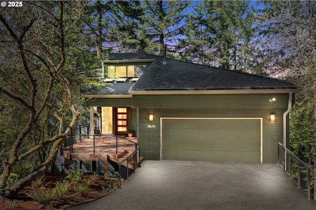 view of front facade with a porch, a garage, aphalt driveway, and a shingled roof
