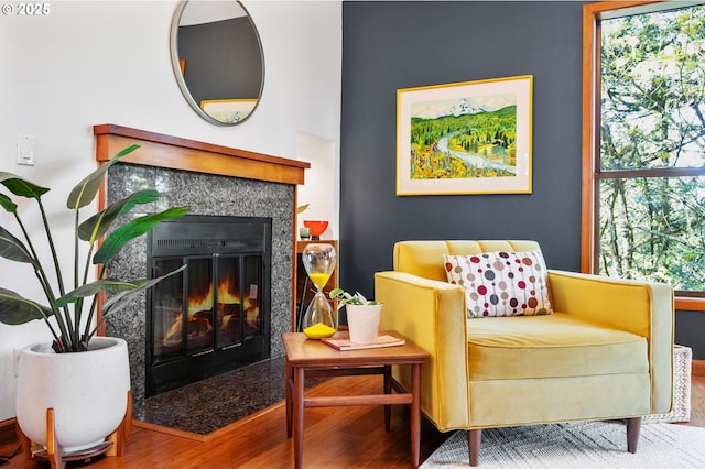 sitting room with wood finished floors and a premium fireplace