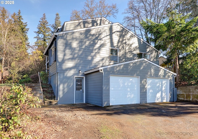 view of side of home with a garage and driveway