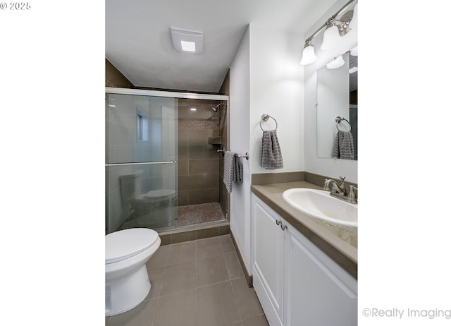 full bathroom with a stall shower, vanity, toilet, and tile patterned floors