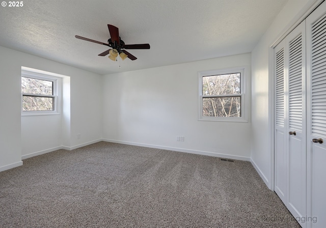 unfurnished bedroom featuring a closet, carpet flooring, and multiple windows