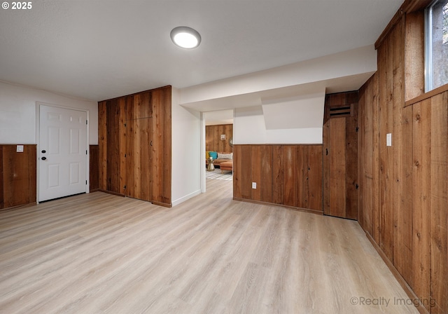 interior space featuring light wood finished floors and wood walls