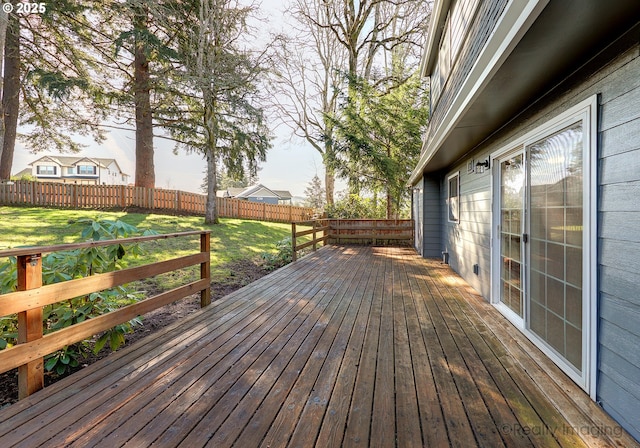 wooden deck with a yard and a fenced backyard