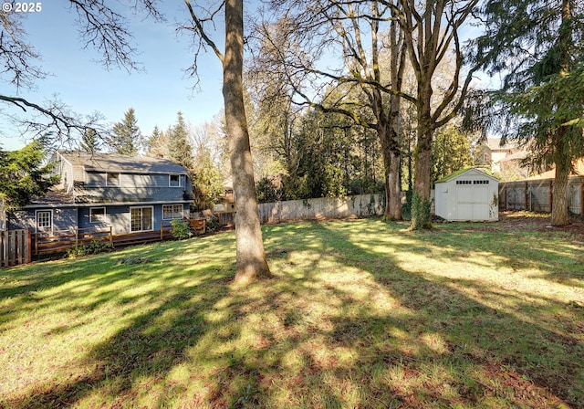 view of yard with a storage unit, an outdoor structure, a fenced backyard, and a wooden deck