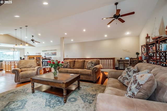 living room with ceiling fan, vaulted ceiling, and light hardwood / wood-style flooring