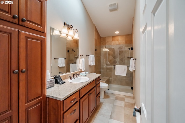 bathroom featuring vanity, a shower with door, and toilet