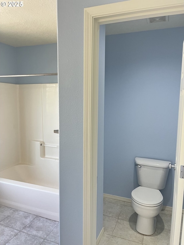 6230 SW Zabaco Ter, Beaverton, OR 97078 - bathroom featuring tile patterned flooring, toilet, baseboards, a textured ceiling, and washtub / shower combination
