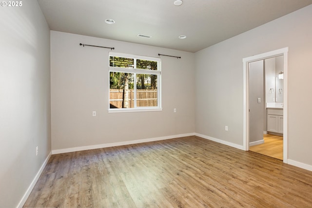 empty room with light wood finished floors, baseboards, visible vents, and recessed lighting