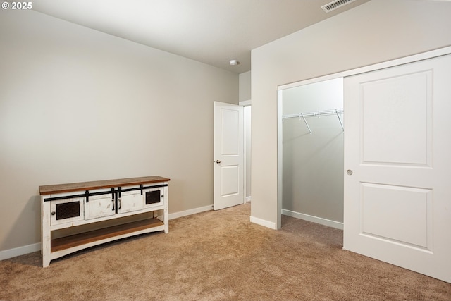 unfurnished bedroom featuring light carpet, a closet, and baseboards