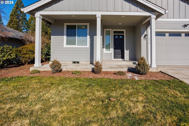 entrance to property with board and batten siding, a yard, a porch, and a garage