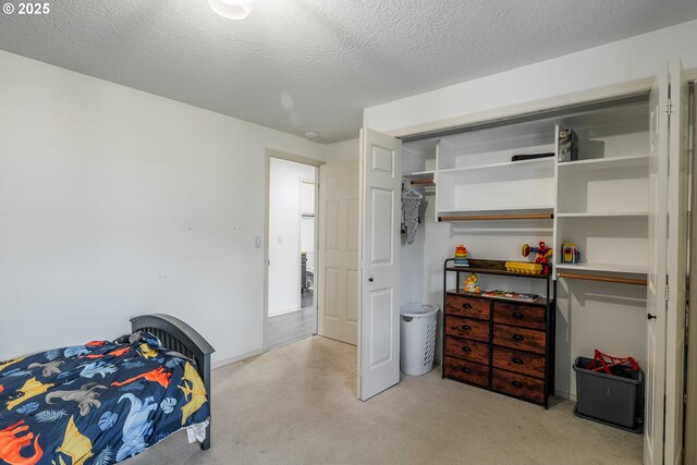 carpeted bedroom featuring a textured ceiling and a closet