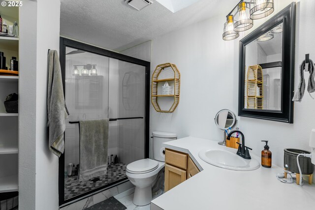 bathroom featuring an enclosed shower, vanity, toilet, and a textured ceiling