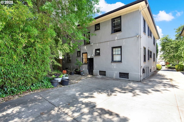 2066 NW Overton St, Portland, OR 97209 - back of house featuring stucco siding, driveway, and a patio area
