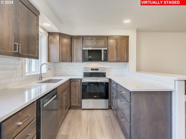 4578 NE Nicholson Loop, Vancouver, WA 98661 - kitchen with appliances with stainless steel finishes, a peninsula, a sink, decorative backsplash, and recessed lighting