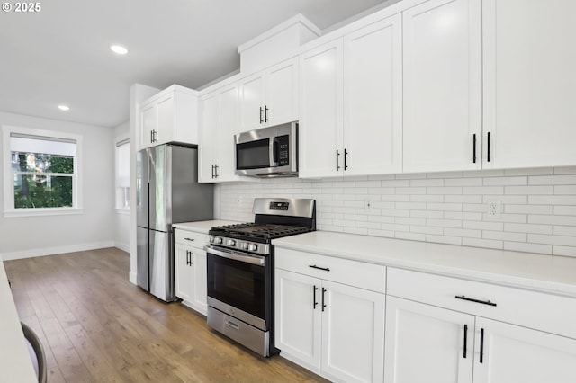 18315 SW Silvertip St, Beaverton, OR 97007 - kitchen featuring appliances with stainless steel finishes, light countertops, white cabinetry, decorative backsplash, and baseboards