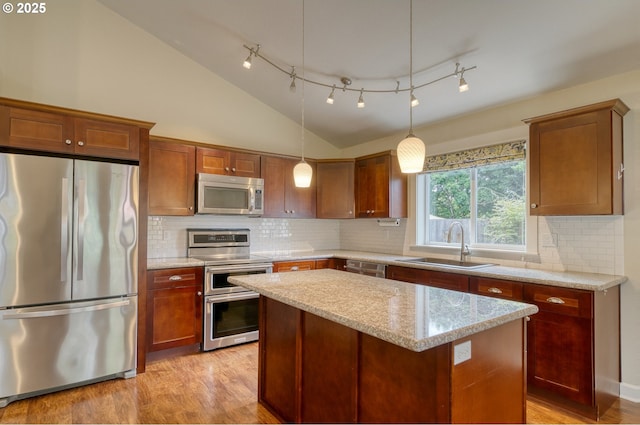 2639 Sykes Rd, Saint Helens, OR 97051 - kitchen featuring appliances with stainless steel finishes, a sink, light wood finished floors, a center island, and vaulted ceiling