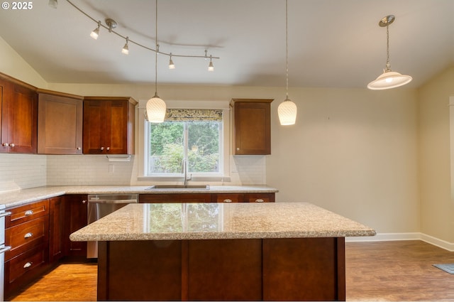 2639 Sykes Rd, Saint Helens, OR 97051 - kitchen with stainless steel dishwasher, a sink, light wood finished floors, decorative backsplash, and a center island