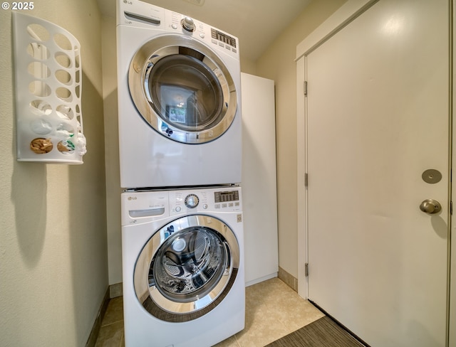 2639 Sykes Rd, Saint Helens, OR 97051 - laundry area featuring stacked washer and clothes dryer, light tile patterned floors, and baseboards