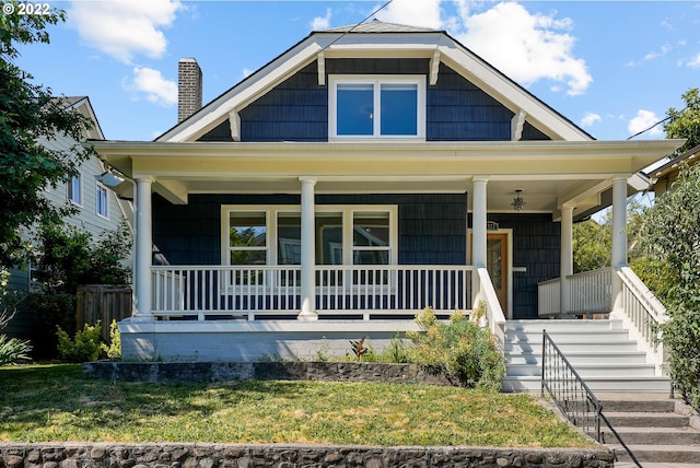 view of front facade with covered porch and a front lawn